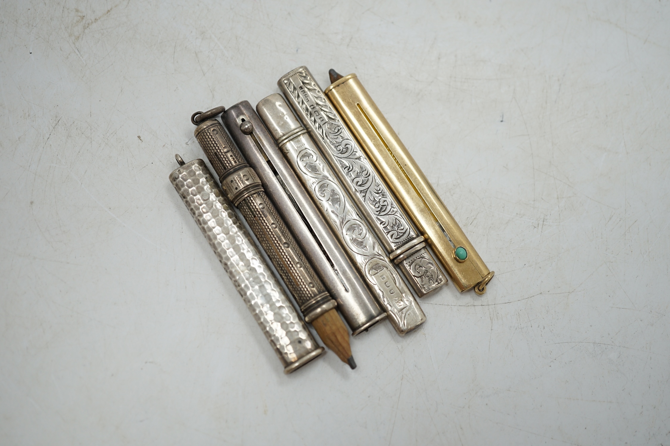An Edwardian Sampson Mordan & Co 9ct gold and turquoise set cased propelling pencil, closed 74mm, together with five silver cased propelling pencils. Condition - fair